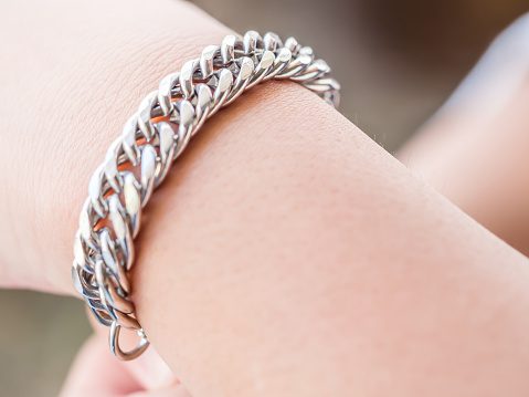 Closeup of silver bracelet and girl hand